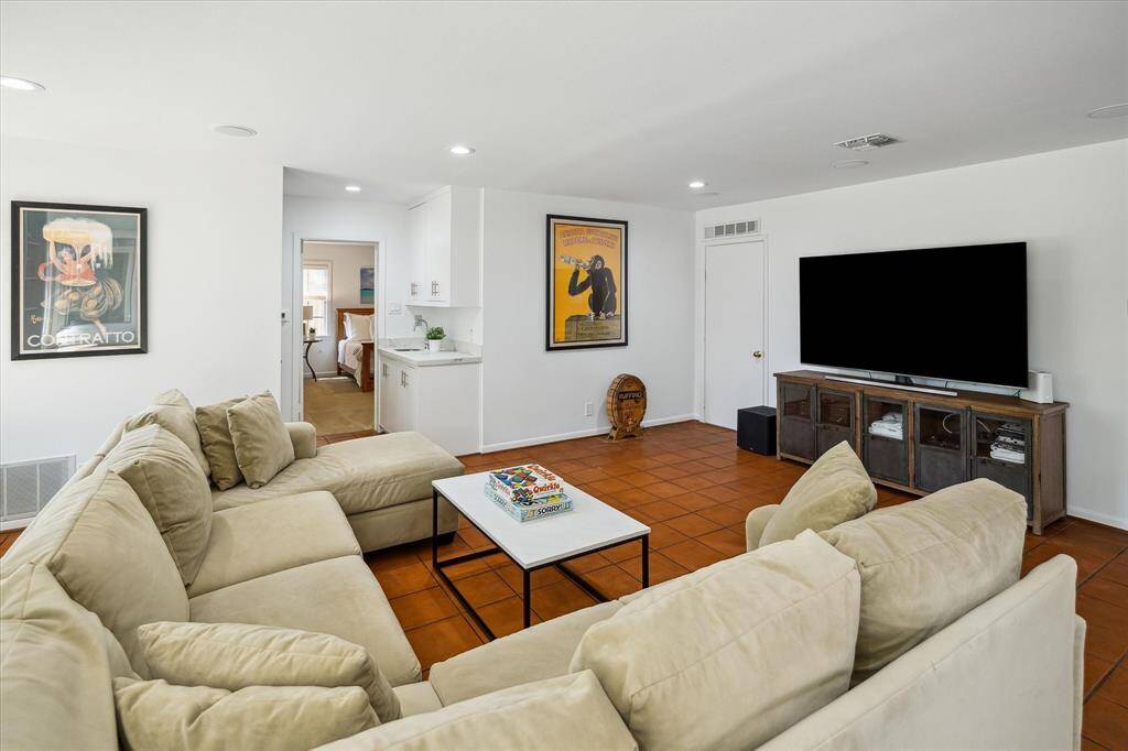 Built-in shelving, seating, and ceiling speakers create a comfortable and functional entertainment space. This game room in the guest house is designed for gathering in style. Elevated finishes and abundant charm make it truly special.