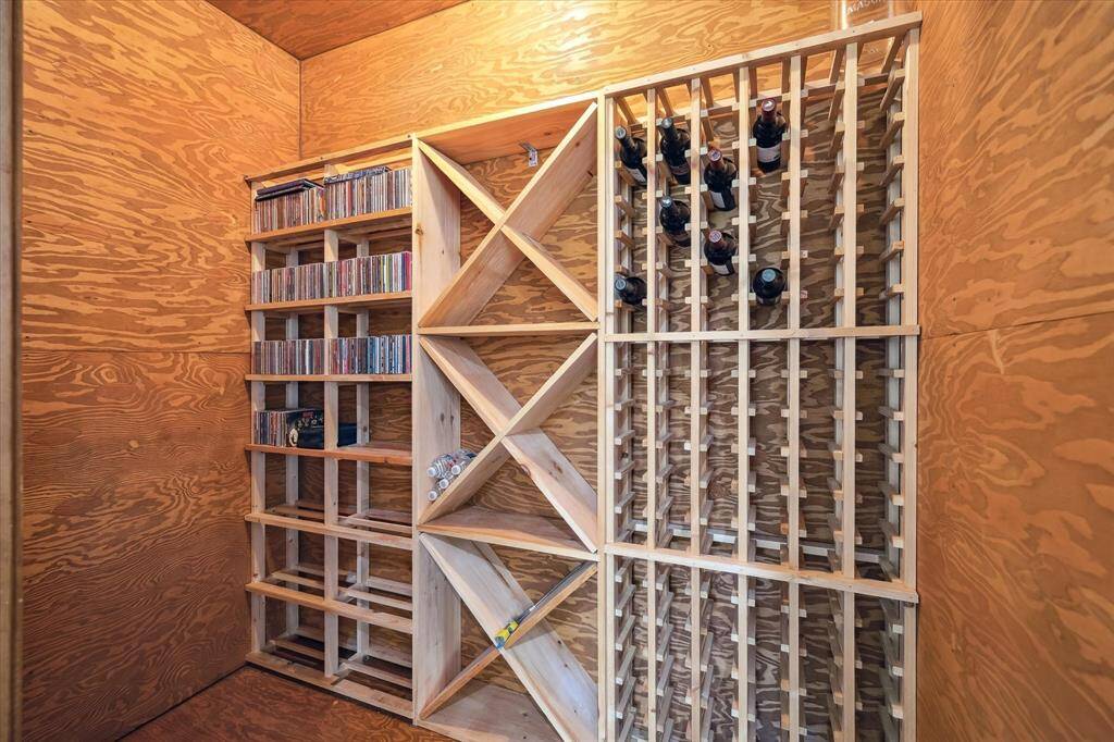An inviting view from the guest house game room reveals a wet bar, wine room, and private bedroom. Designed with guests in mind, every feature enhances the comfort and experience. A private retreat with entertainment built in.