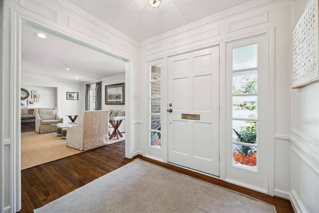The front entry boasts intricate custom millwork and flows effortlessly into the formal living spaces. A coat closet offers discreet functionality just steps from the front door. Sophisticated design meets seamless livability from the moment you arrive.