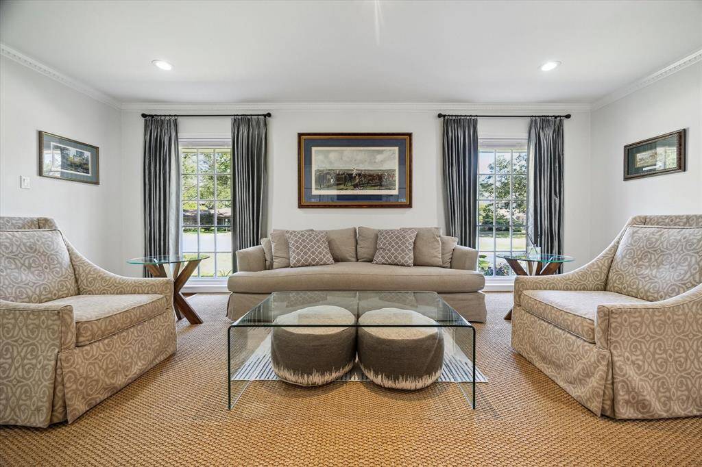 This expansive formal living room seamlessly connects the entry and dining areas, creating ideal flow for entertaining. Thoughtfully designed for both form and function. Refined millwork and architectural details enhance its grand presence.