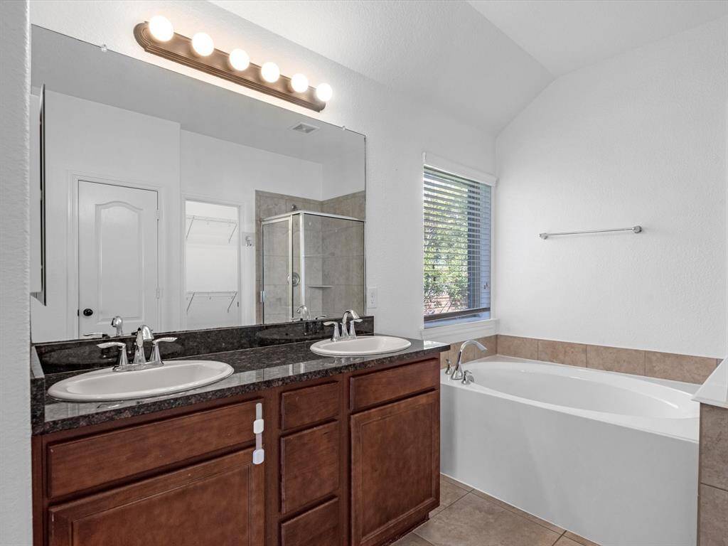 The ensuite primary bathroom has no wasted space: an efficient countertop with two sinks, and separate shower and soaking tub.
