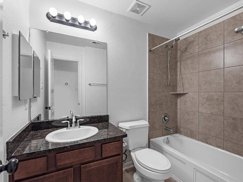 The second full bathroom is located between the downstairs secondary bathrooms and features a tub/shower combo, single vanity and medicine cabinet.