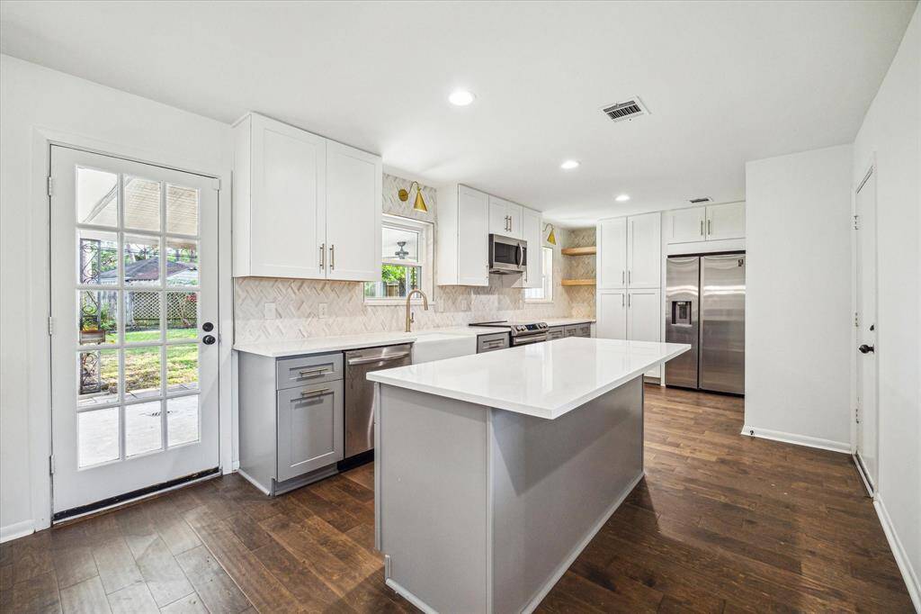 Marble backsplash in kitchen with quartz countertops. Beautiful brass accents make this kitchen truly special.