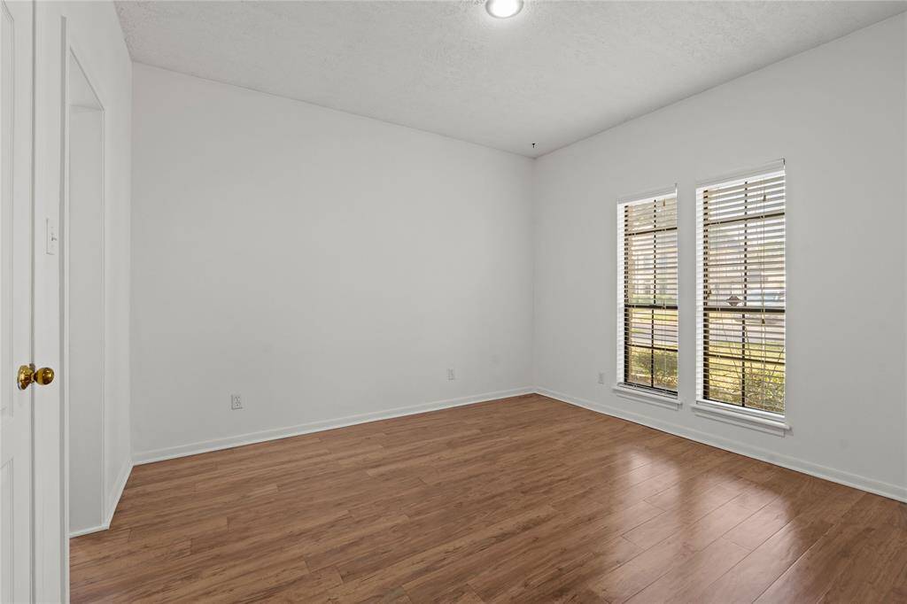 Bedroom 2: This bright and inviting room is a perfect blend of comfort and versatility! The warm wood flooring adds a touch of elegance, while the large windows with classic blinds let in an abundance of natural light, creating a cheerful and airy atmosphere. The neutral walls provide a blank canvas, ready for your personal touch-whether as a cozy bedroom, a productive home office, or a stylish guest space.