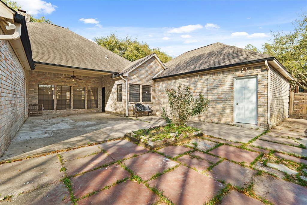 This expansive backyard patio is the perfect outdoor retreat, offering both covered and open-air spaces for relaxation and entertainment. The charming brick exterior, paired with the rustic stone pavers, creates a timeless and inviting atmosphere.Whether you're hosting summer barbecues, setting up a cozy fire pit, or enjoying a quiet morning coffee under the covered patio with its cooling ceiling fan, this space is ready to be transformed to suit your lifestyle. With plenty of room for outdoor seating