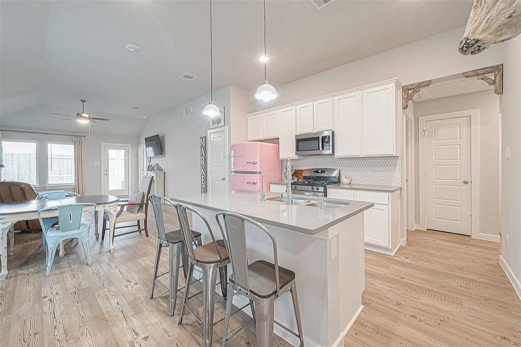 Secondary view of kitchen. Freestanding island with undermount sink and dishwasher. Ample counter space and overhang for barstools.
