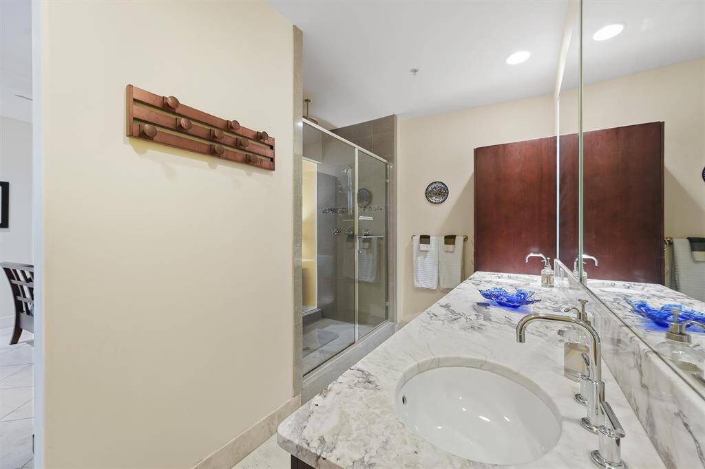 Primary bathroom featuring an oversized walk-in shower, double vanities, and abundant storage