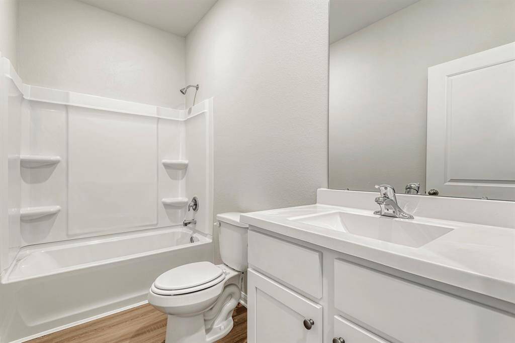The centrally located secondary bathroom has an upgraded shower/bath combo and single basin sink with beautiful cabinetry.