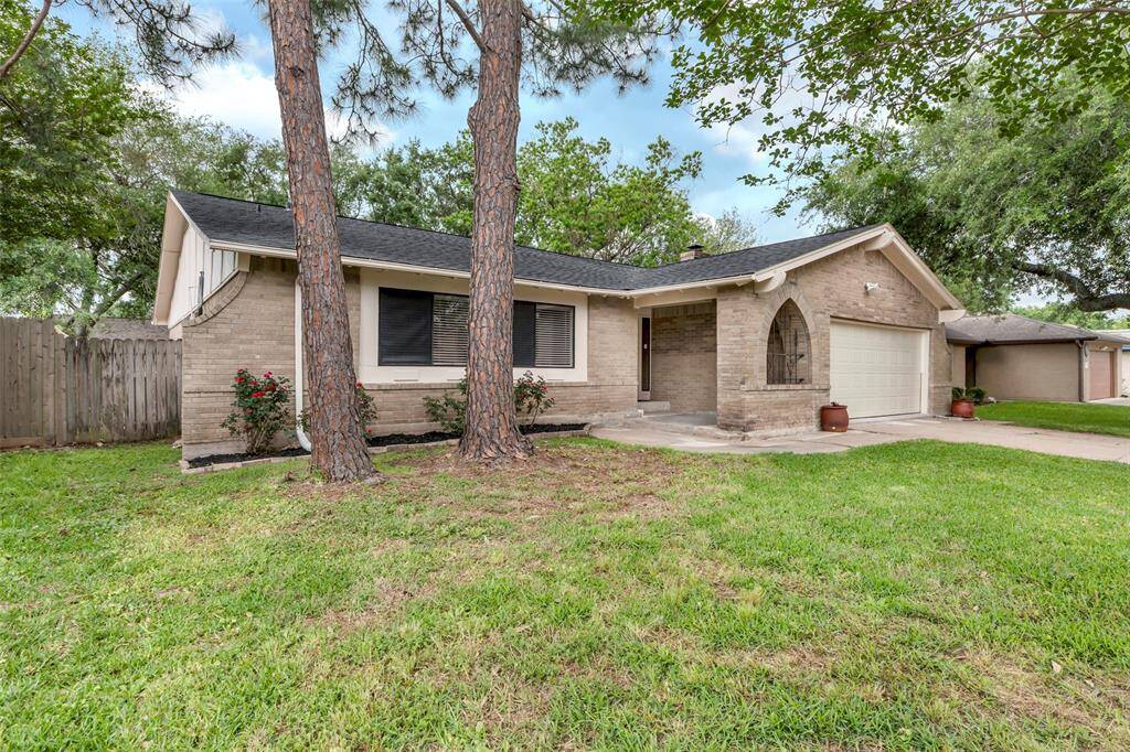 Charming single-story brick home with a cozy front porch and attached garage. Surrounded by a lush, green lawn with mature trees, the property offers a welcoming and serene atmosphere.