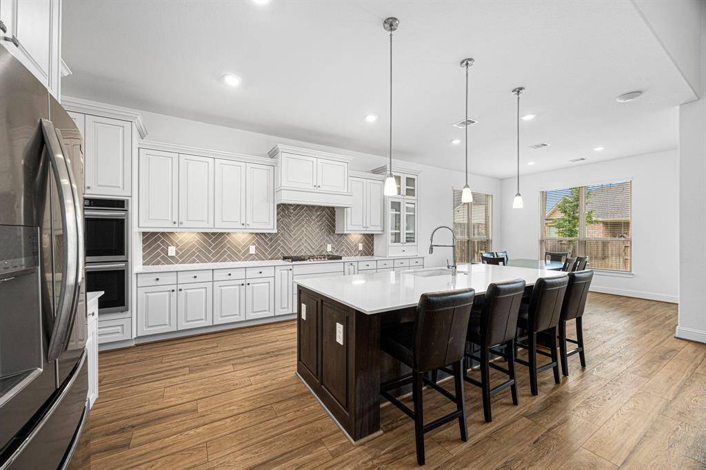 This kitchen is sure to WOW you! White cabinetry, quartz counter tops, SS appliances, and a large island great for food prep.
