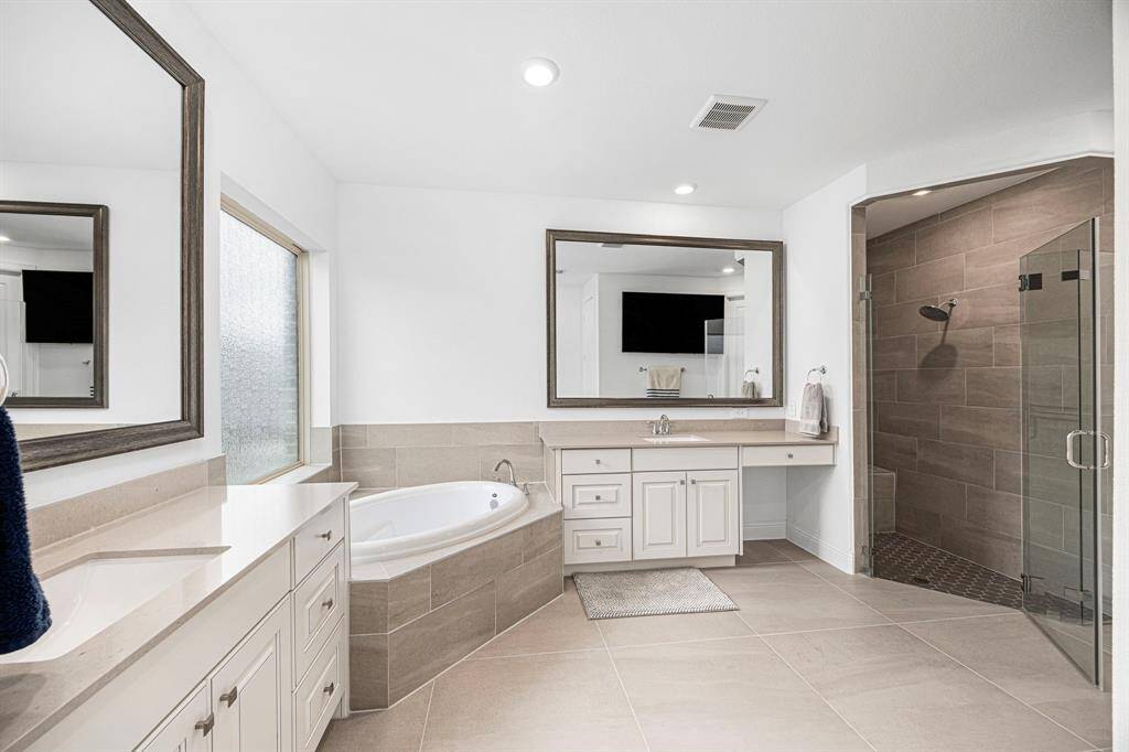 Impeccable primary bath with double sinks, vanity, soaker tub and large walk-in shower.