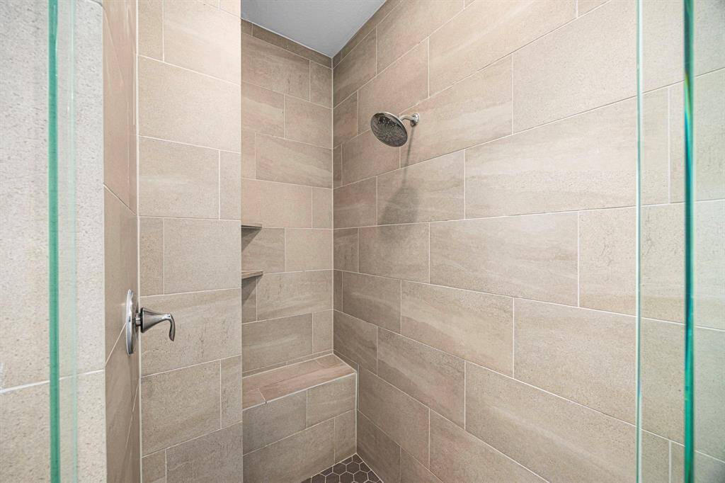 Large walk in shower with bench.