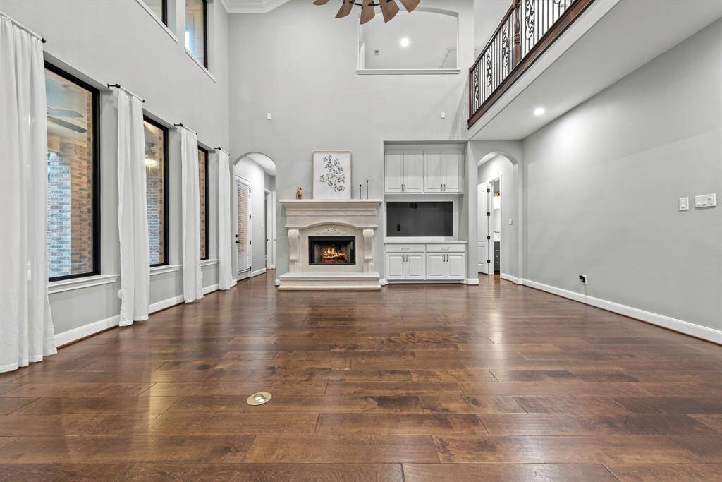 Wood flooring in all main living spaces, floor plug and balcony viewing from second story.