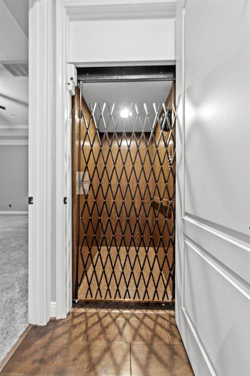Elevator closet leading to upstairs secret room with call button and hard line phone.
