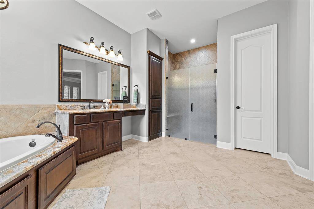 Obscured glass doors on walk in shower, tile to ceiling walls.