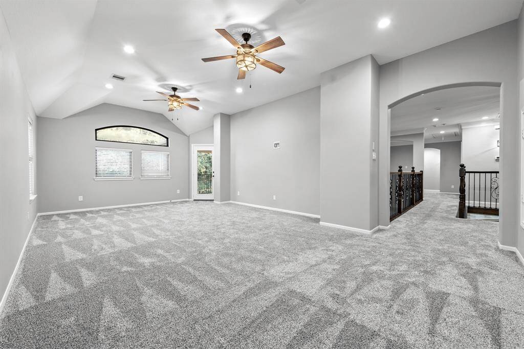 Large upstairs game room with covered balcony access overlooking backyard oasis.