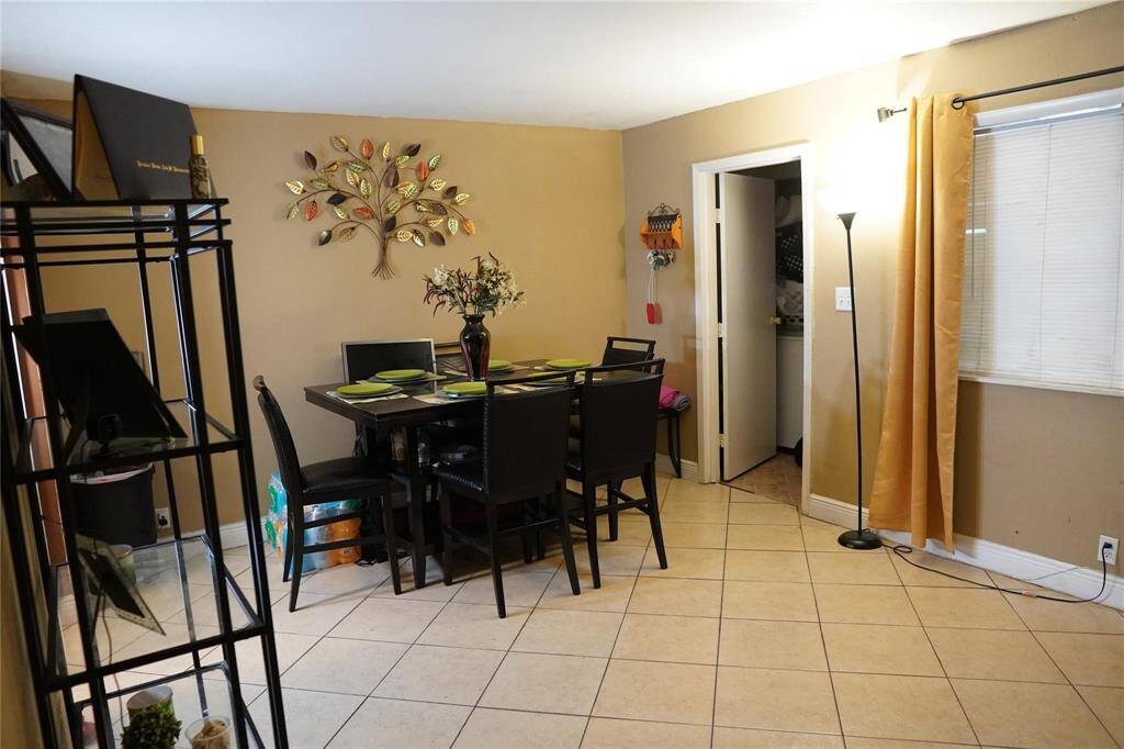 The den seamlessly flows into a dining room, creating an ideal space for both everyday living and entertaining guests.