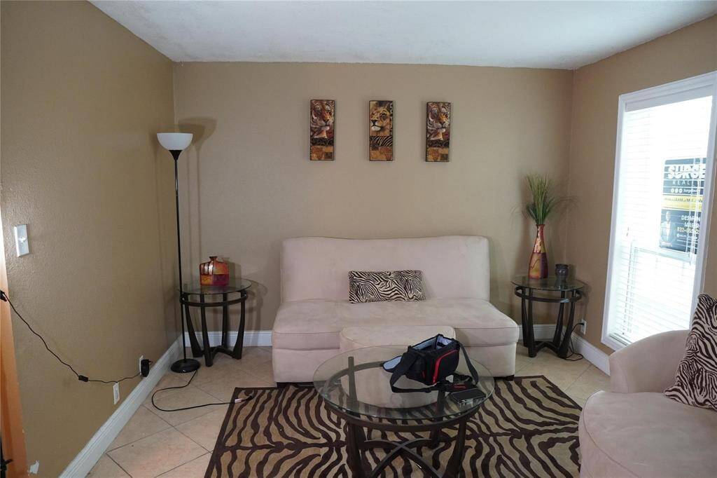 Upon entering, you are greeted by a warm and open living space accentuated by tile flooring.