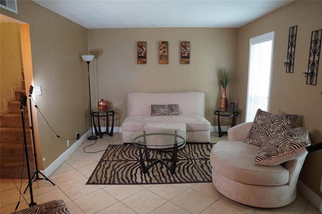 Upon entering, you are greeted by a warm and open living space accentuated by tile flooring. The stairs are to the left leading you upstairs to the bedrooms.