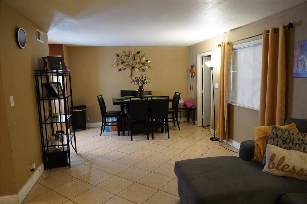 The den seamlessly flows into a dining room, creating an ideal space for both everyday living and entertaining guests.