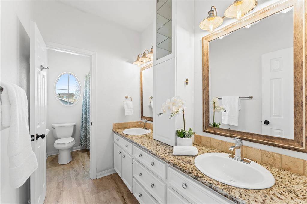Thoughtful design at its best—dual vanities, a separate shower/tub space, and chic French country-inspired finishes make this bathroom both beautiful and functional.