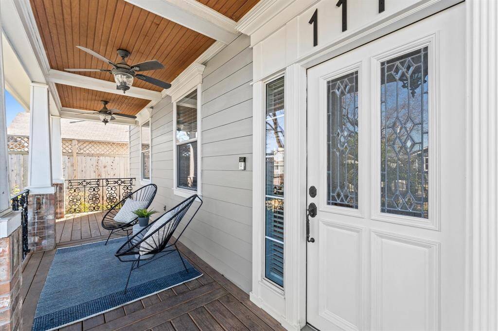 Take a seat and stay awhile! Two ceiling fans keep things breezy, while the stunning leaded glass entry door hints at the thoughtful design waiting inside.