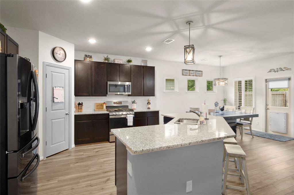Large kitchen with gas cooktop and refrigerator remains with the home.