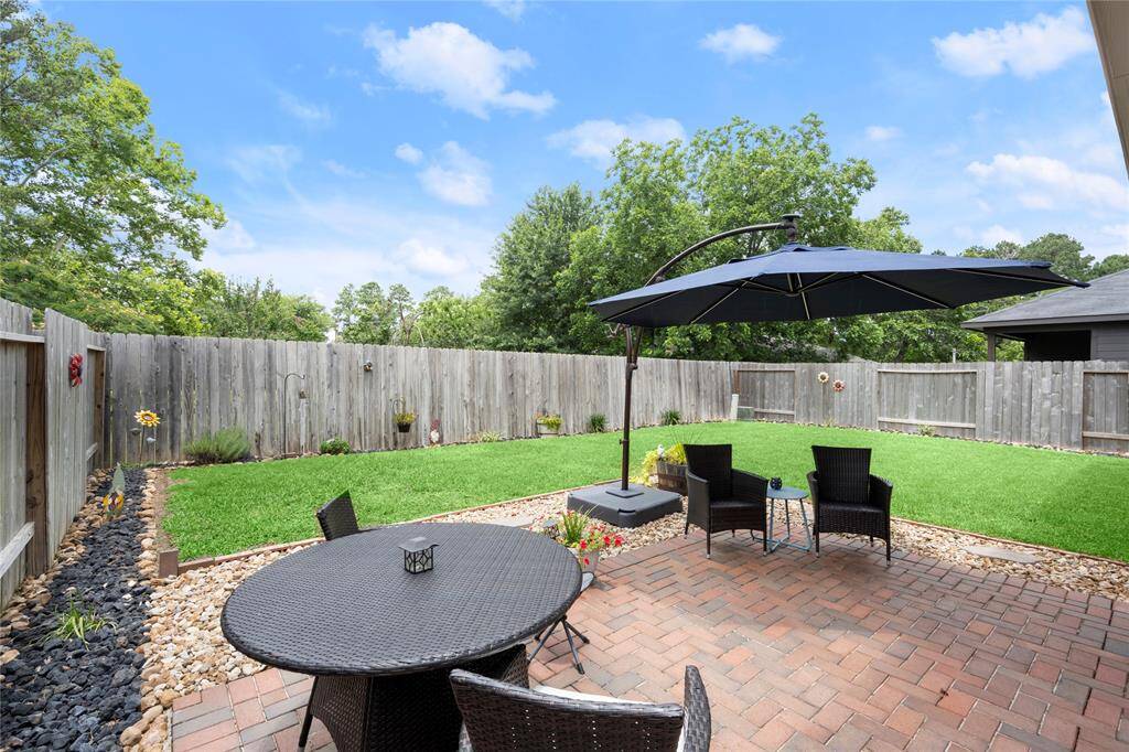 Paved back patio with yard backing up to acreage.