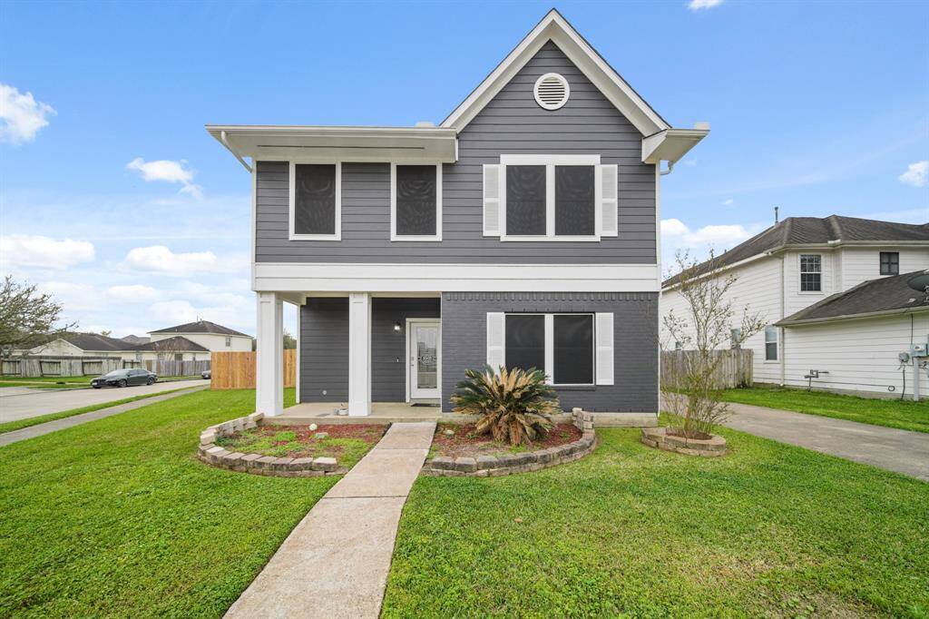 This is a two-story house with a modern exterior featuring gray siding and white trim. The home is situated on an oversized corner lot:
