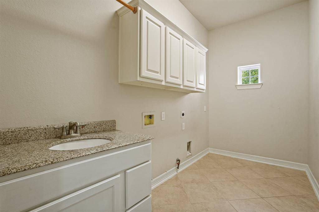 Laundry room has space for second fridge and has a sink.