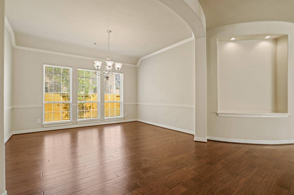 Dining room features polished wood floors and neutral paint.