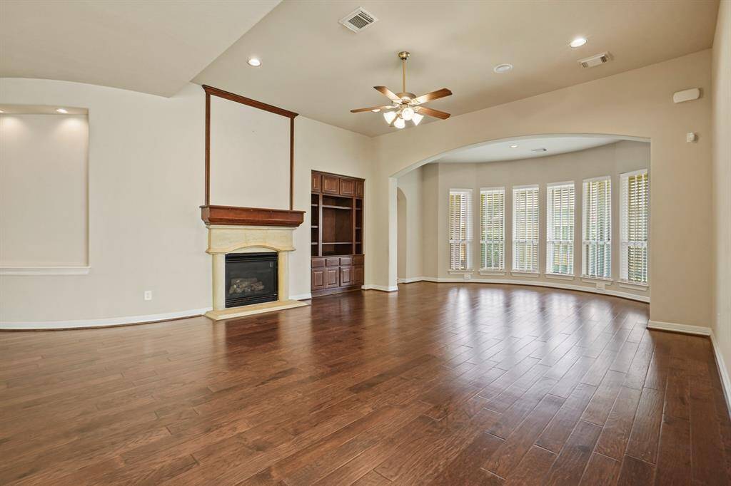 Huge living room offers gas fireplace and built in bookcase.