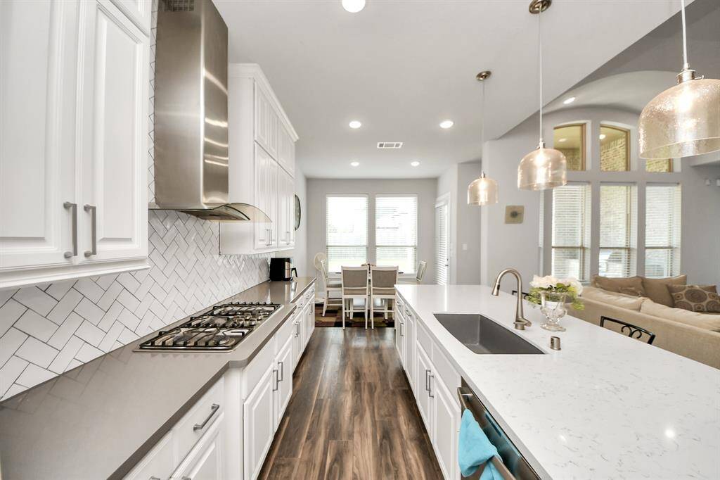A beautifully designed kitchen featuring sleek cabinetry with convenient pot and pan drawers, complemented by the warm glow of recessed lighting!