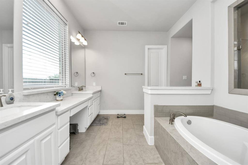 Clean & bright, the primary bathroom is vast with plenty of room during the early morning rush.