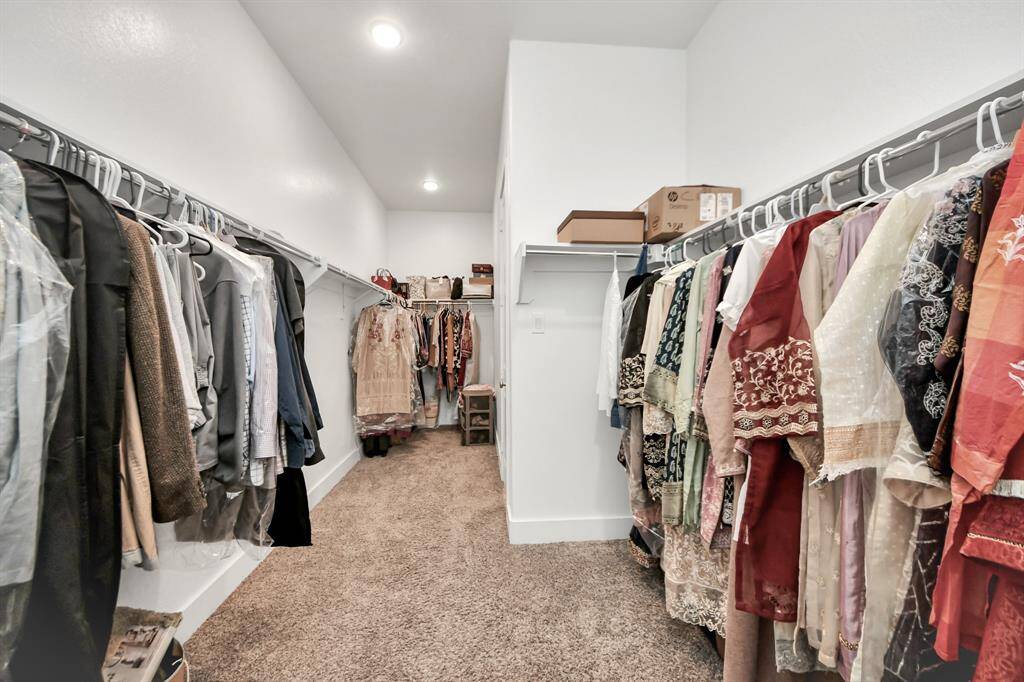 Discover the ultimate functionality in this primary closet, showcasing a harmonious blend of neat shelves and practical storage!