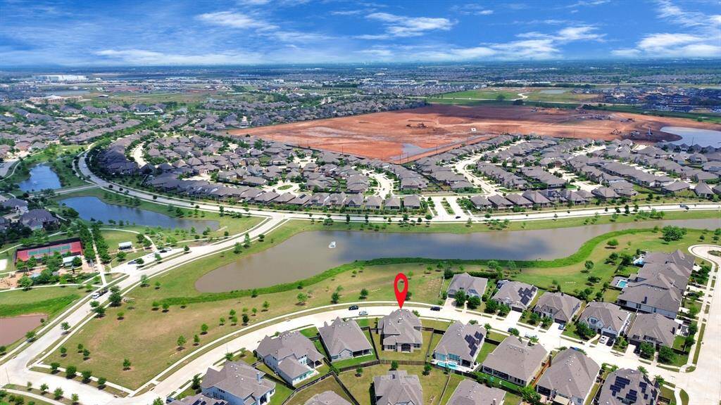 This aerial photo of the very desirable community, Harvest Green with Lakes, walking trails and community pools makes Harvest Green wonderful place to call home. A red marker highlights property for sale.