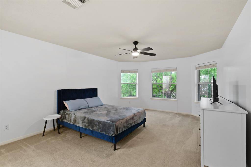 This secondary bedroom is massive overlooking the beautiful trees in the front yard.