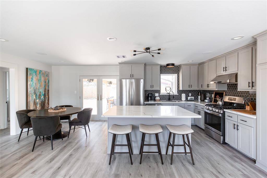 Nice kitchen to gather in.  Tons of cabinets, quarts counters, stainless appliances and breakfast bar.  Dining space joins this great kitchen.  Backdoor leads into the backyard with great space to entertain in,