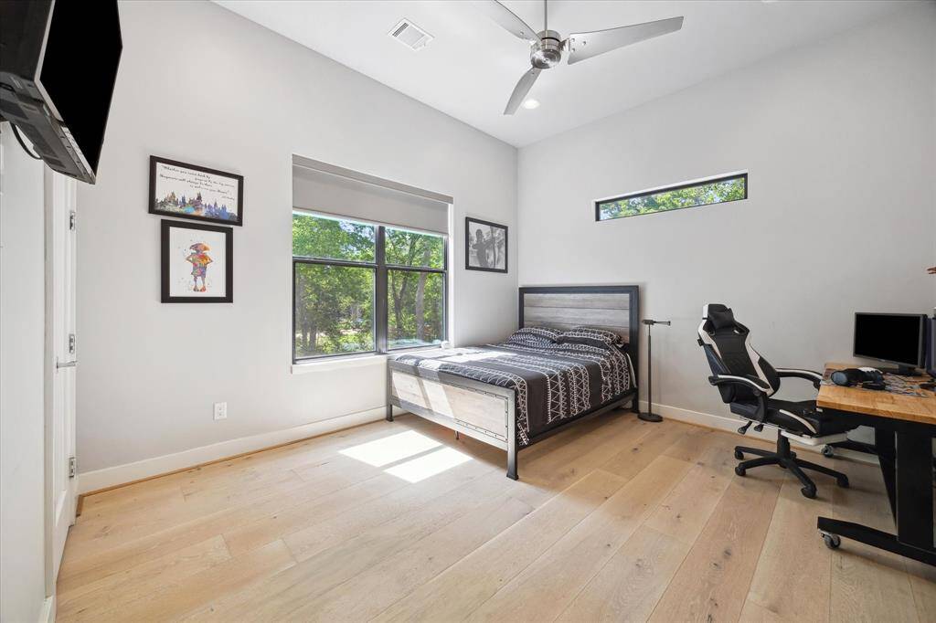 Secondary bedroom features awindow, high ceilings, and recessed lighting.