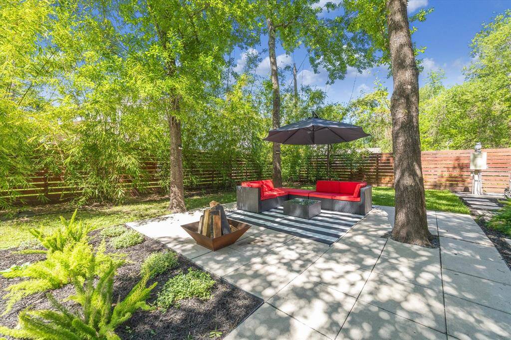 Tall trees provide plenty of shade and a paved walkway leads to an additional sitting area.