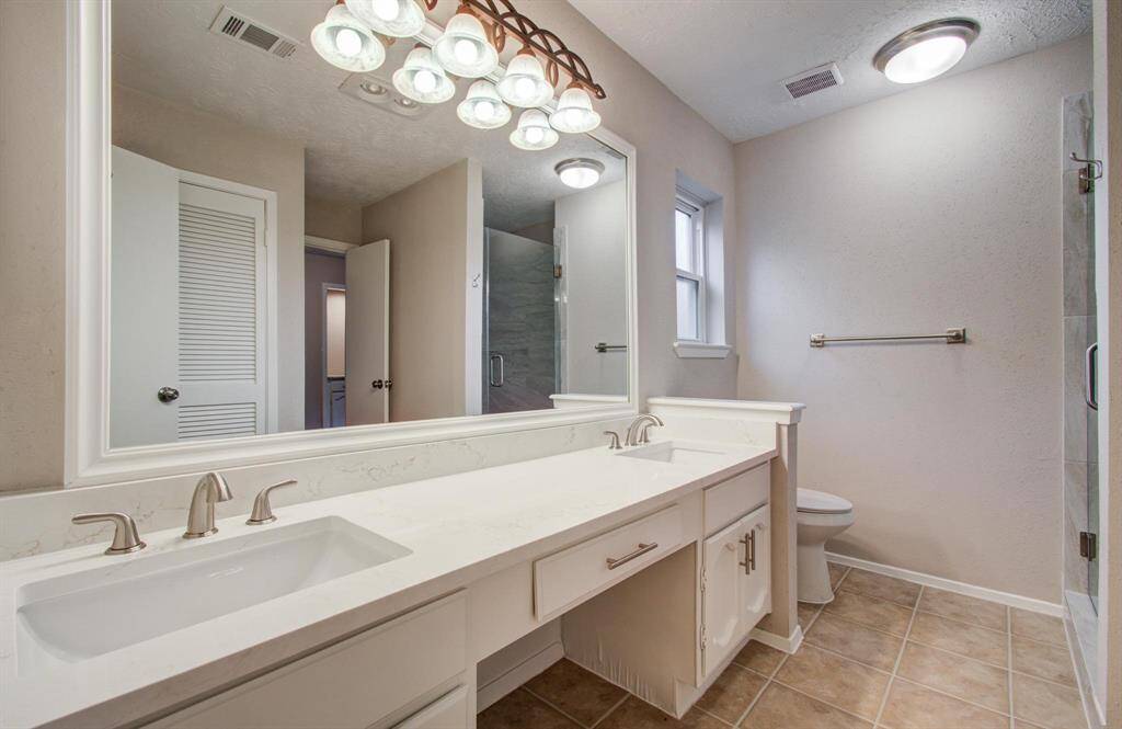 Master Bathroom features dual undermount sinks and has been updated with quartz counters, new faucets and light fixtures.
