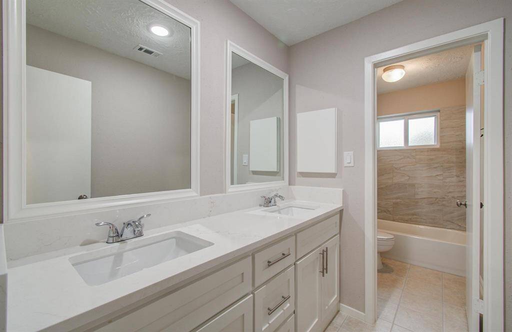 2nd Full Bathroom features dual undermount sinks, and has been updated with new cabinets, fixtures, quartz counters and tile in the tub shower.