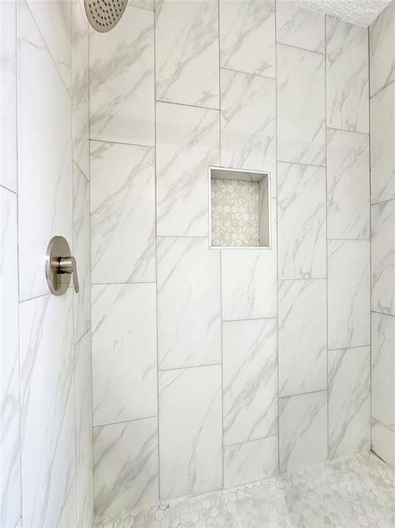 Remodeled shower with calacata tile and new upgraded fixtures