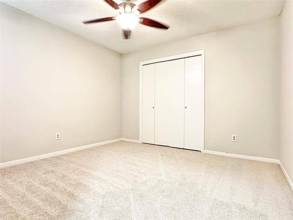 Secondary bedroom new carpet an upgraded ceiling fan.