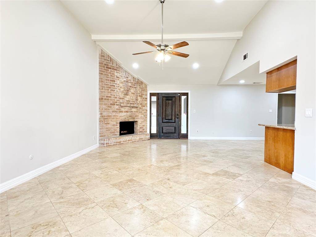 Spacious living area with high ceiling and travertine floors, neutral fresh paint and colors throughout.