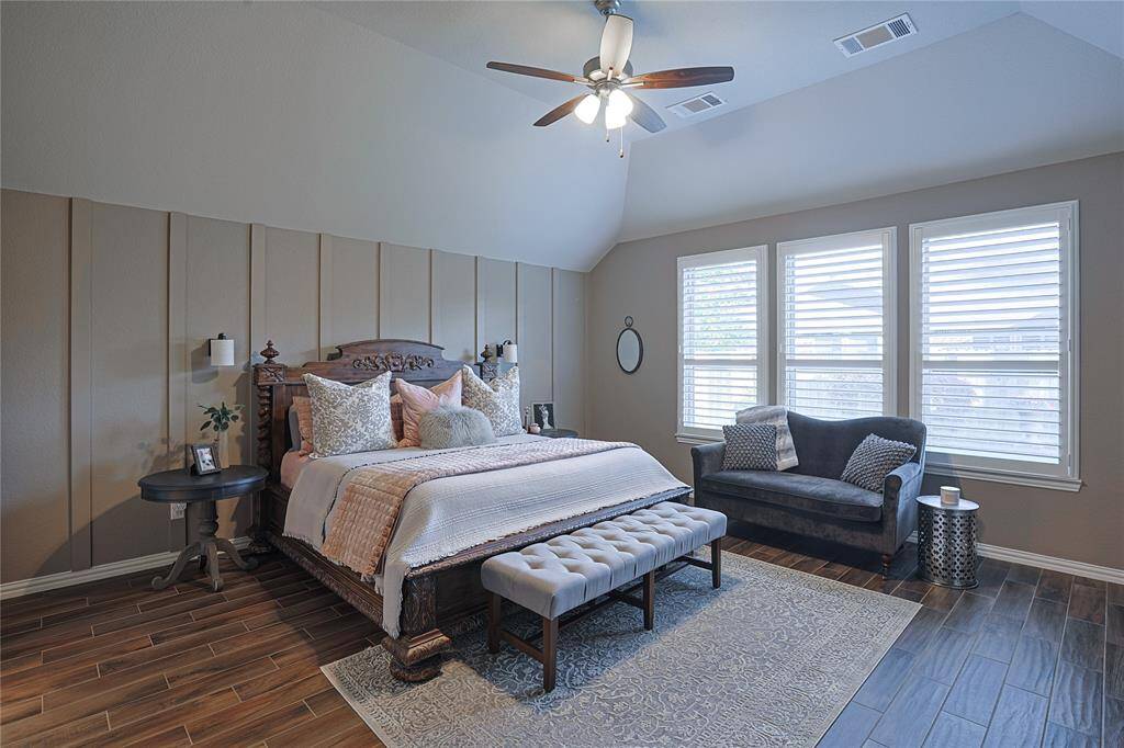 Spacious primary with extended suite option features custom accent wall, plantation shutters and TONS of natural light