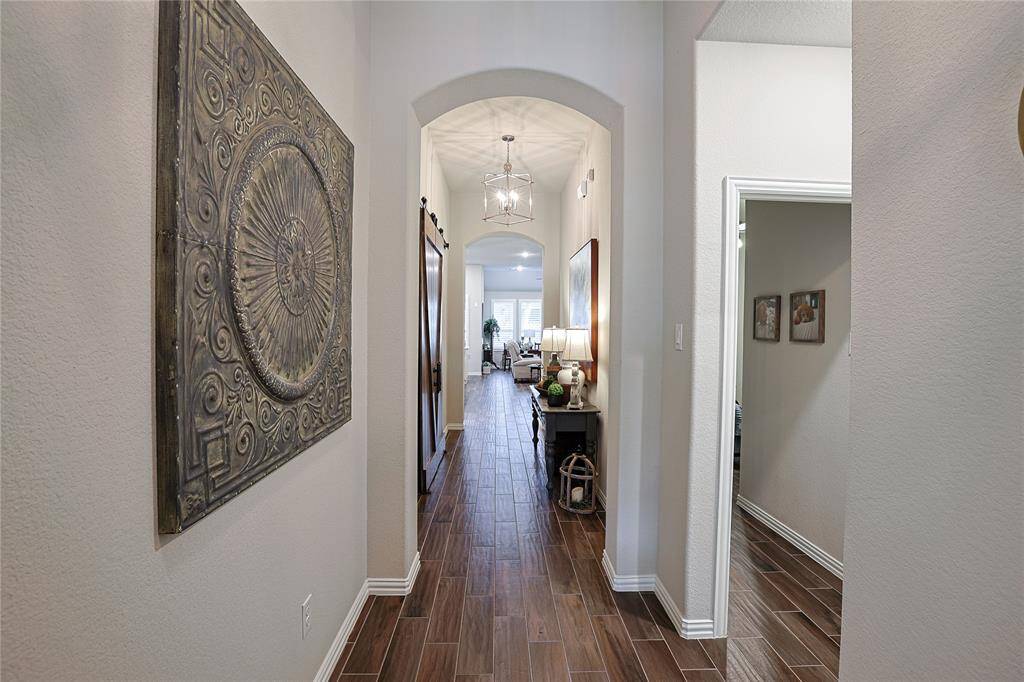Arches and handsome wood look tile are standout features of this home