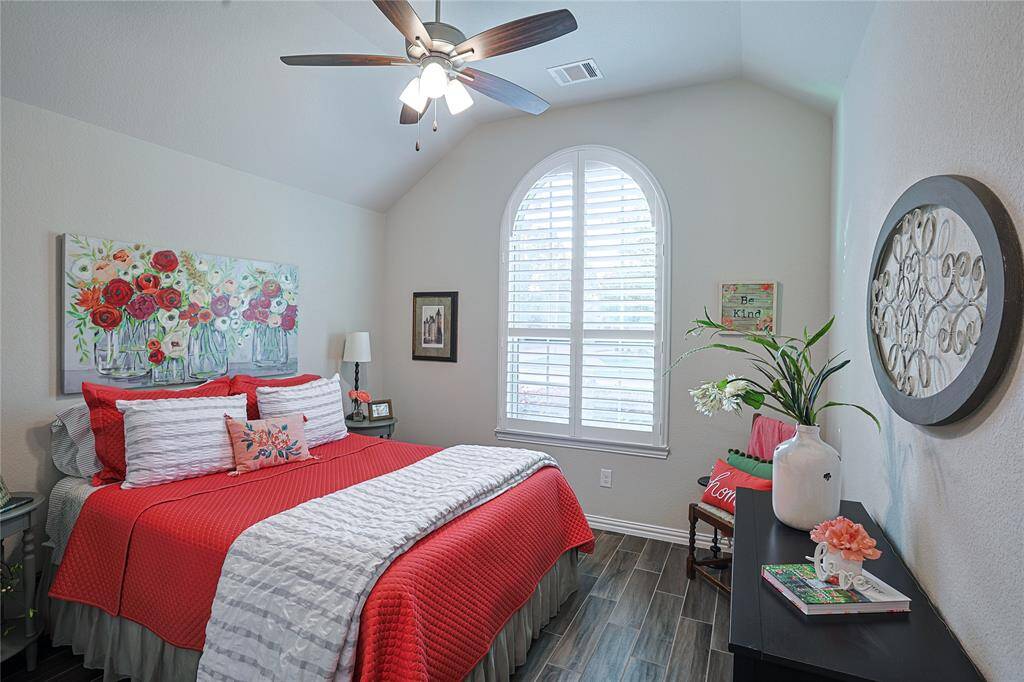 Plantation shutters are found throughout the home as shown in this secondary bedroom located to the front of the home