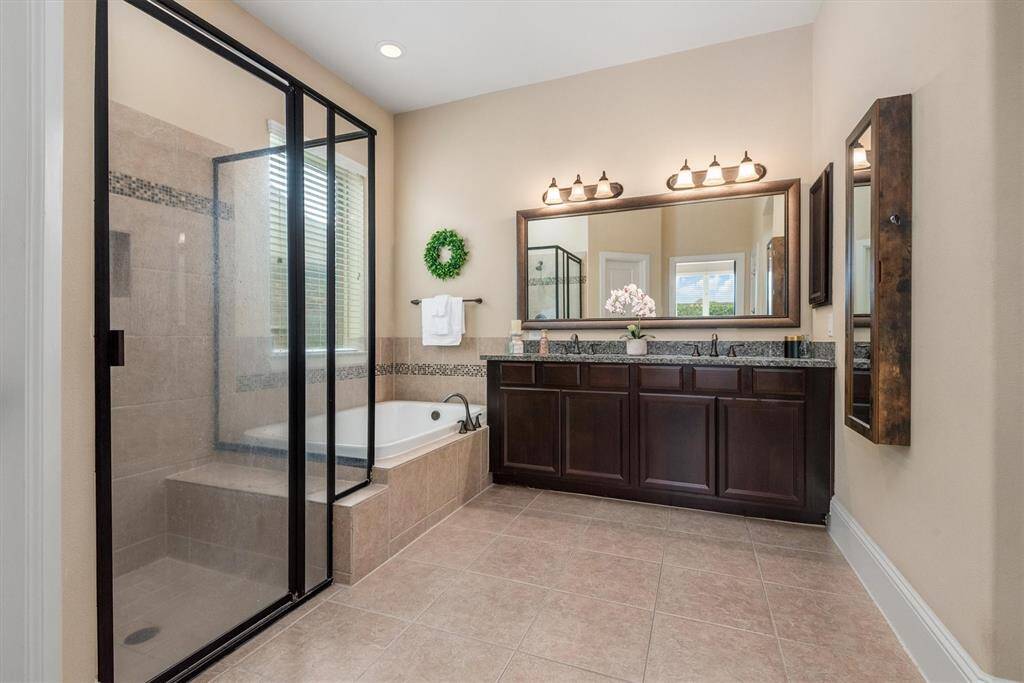 The primary bathroom features dual vanities, a luxurious soaking tub, an oversized shower as well a large walk in closet.