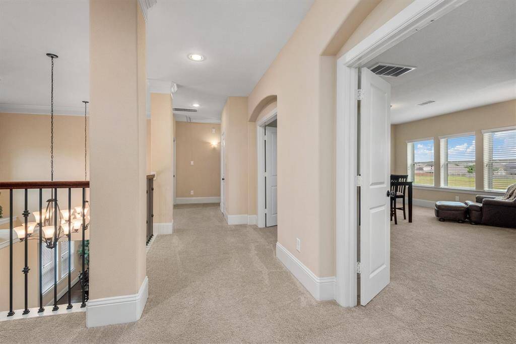 The expansive hallway upstairs overlooks the main floor and leads to the bedrooms and huge upstairs gameroom.
